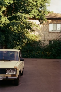 A well-kept classic car parked quietly on a charming UK village street under soft daylight.