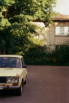 An old classic car parked on a quiet street, showing acceptance of older vehicles.