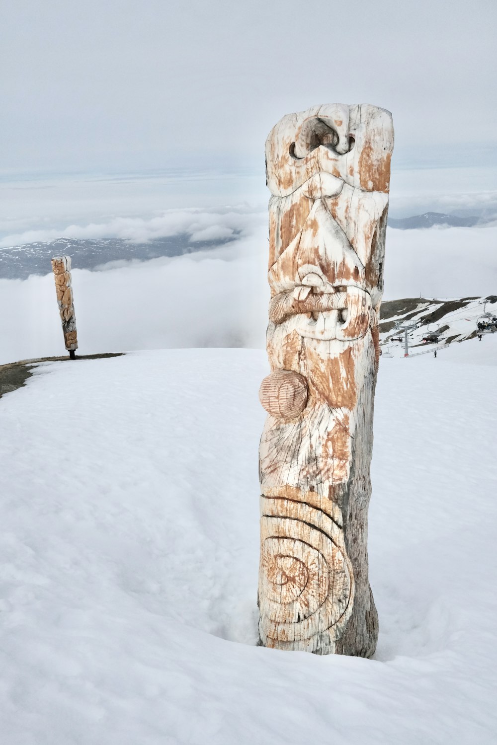 a wood post with carvings on it in the snow