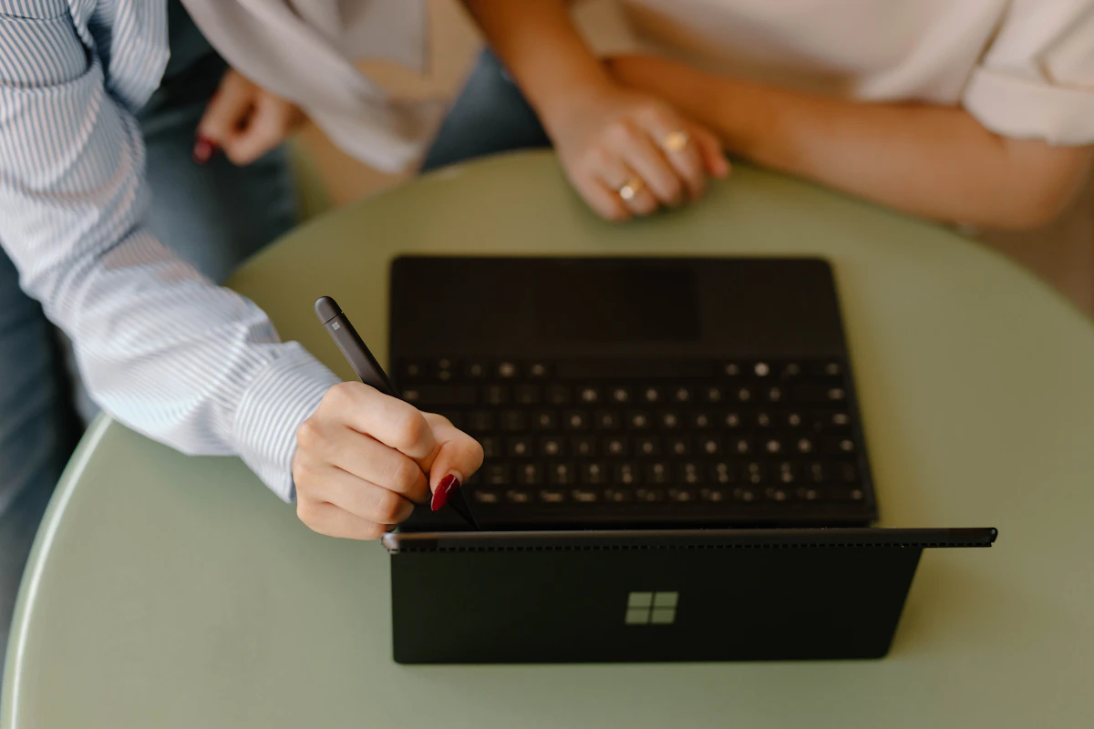 Creative professionals collaborating around a laptop during a client work session