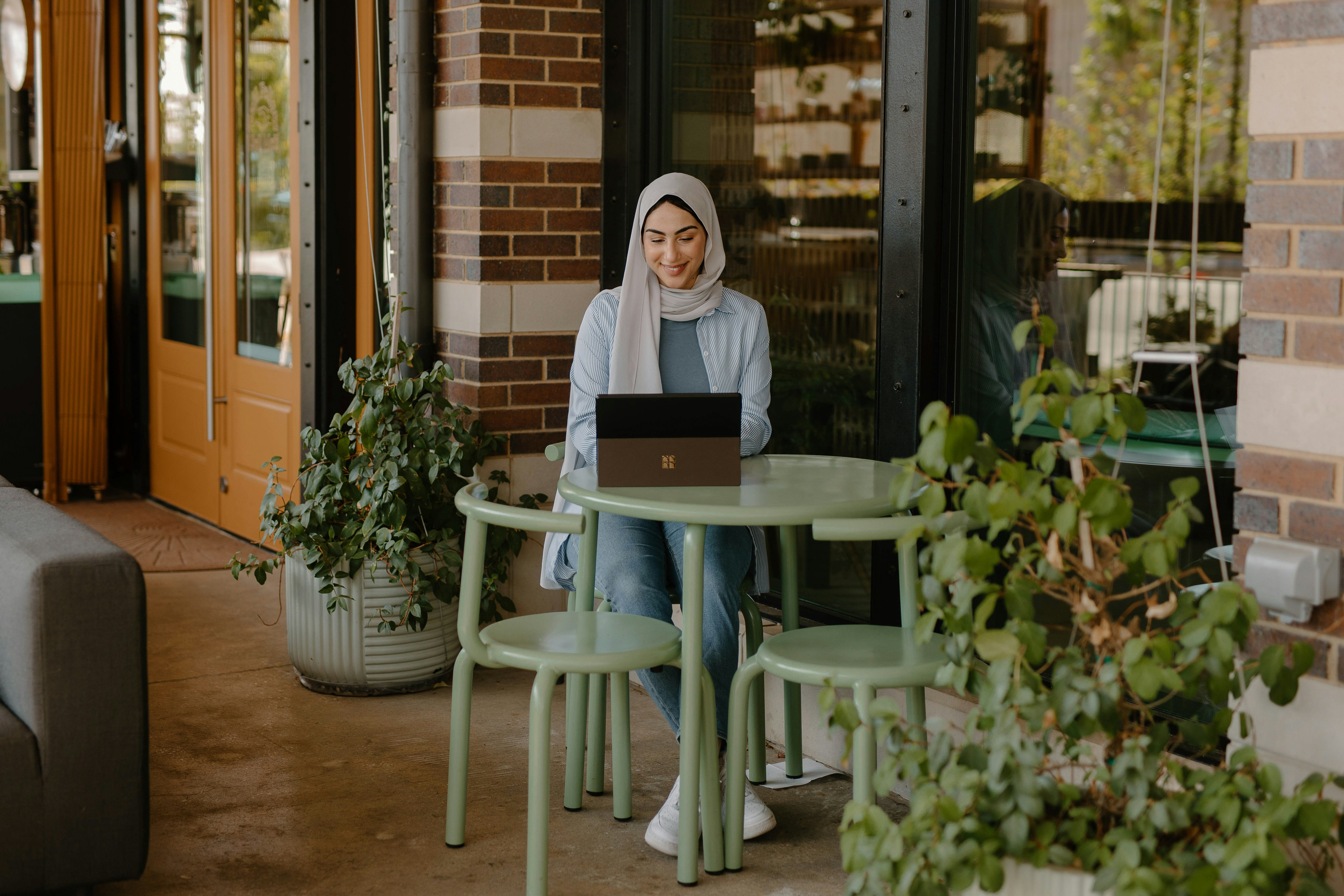 a person sitting at a table with a laptop