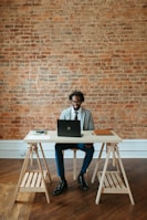 a man sitting at a table with a laptop on it