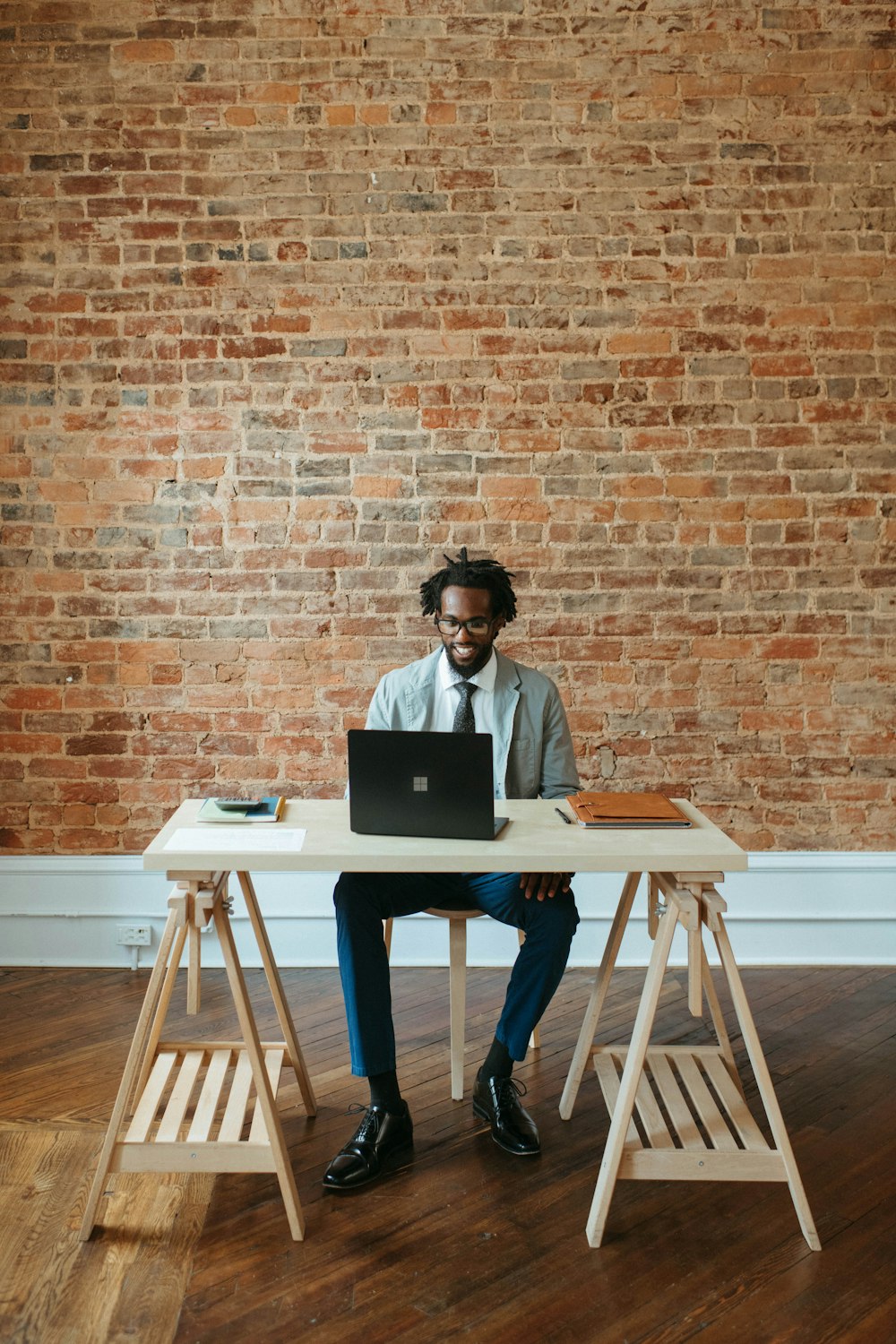 a man sitting at a table with a laptop on it