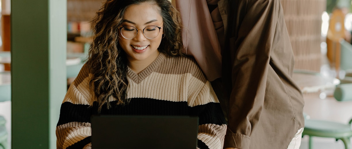 a woman and a girl looking at a laptop