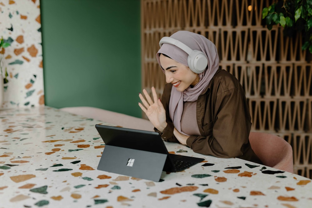 Eine Person, die mit einem Laptop auf einem Tisch sitzt