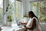 a woman sitting at a table with a laptop