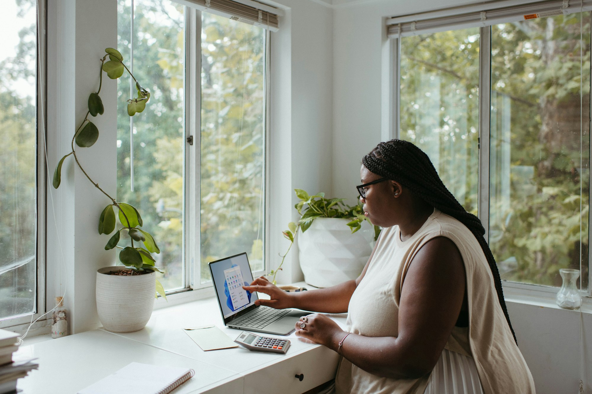 A woman reviews information on her computer as she works from home.