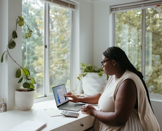 a woman sitting at a table with a laptop