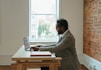 a person sitting at a desk with a laptop and papers