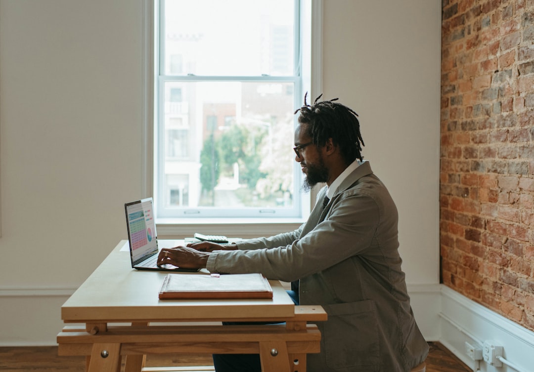 A man dedicated to delivering effective Staffing solutions using a laptop