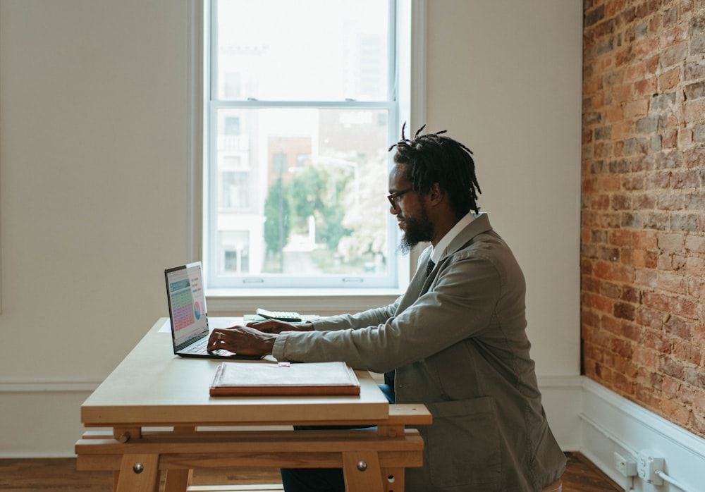 Una persona sentada en un escritorio con una computadora portátil y papeles