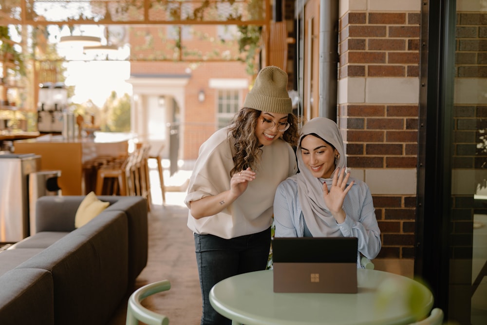 une femme assise à une table utilisant un ordinateur portable