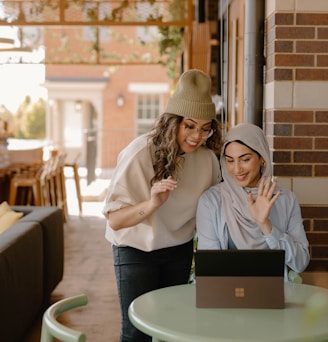 a woman sitting at a table using a laptop