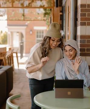 a woman sitting at a table using a laptop