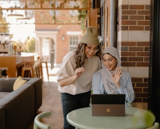 a woman sitting at a table using a laptop