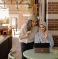 a woman sitting at a table using a laptop