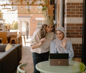 a woman sitting at a table using a laptop