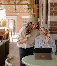 a woman sitting at a table using a laptop