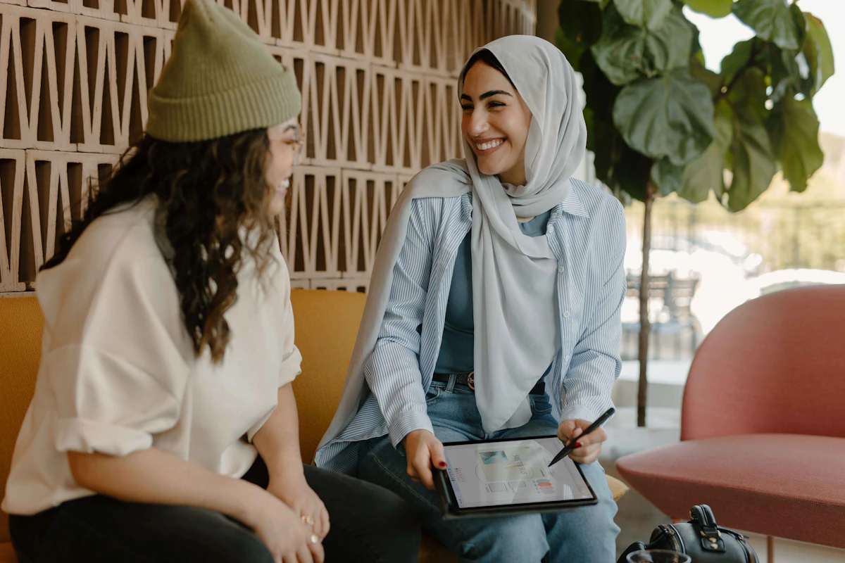 Two colleagues talking warmly over a tablet