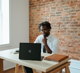 a man sitting at a table in front of a laptop