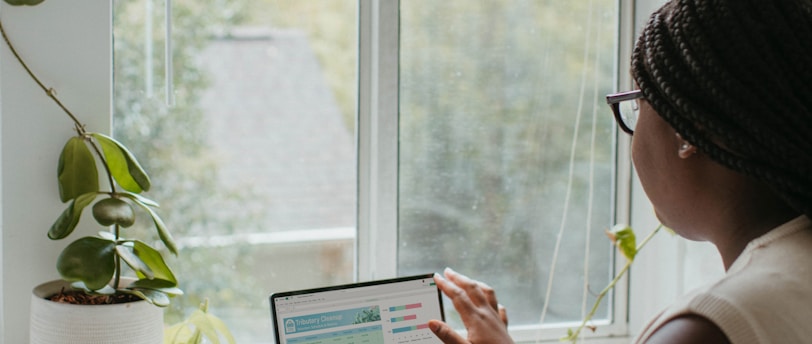 a woman sitting at a table using a laptop computer