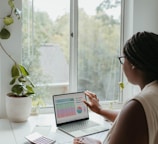 a woman sitting at a table using a laptop computer