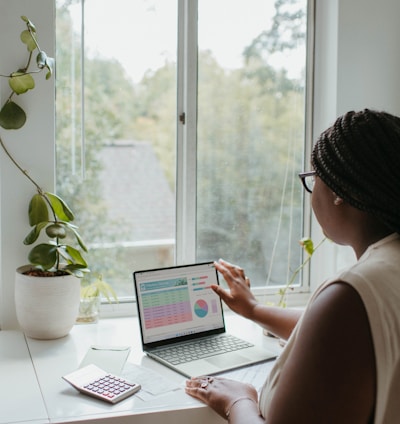 a woman sitting at a table using a laptop computer