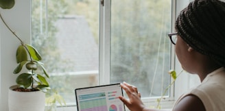 a woman sitting at a table using a laptop computer