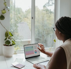 a woman sitting at a table using a laptop computer