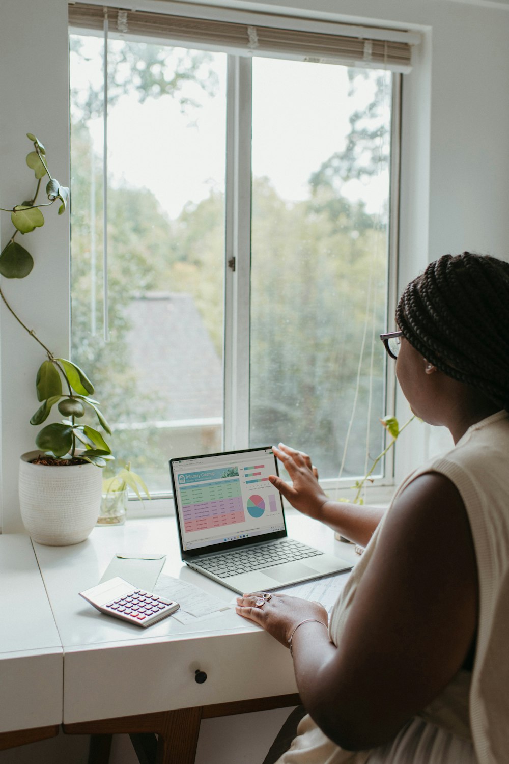 a woman sitting at a table using a laptop computer