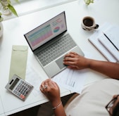 a person sitting at a table with a laptop