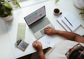 a person sitting at a table with a laptop