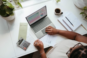 a person sitting at a table with a laptop