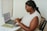 a person sitting at a table using a laptop computer