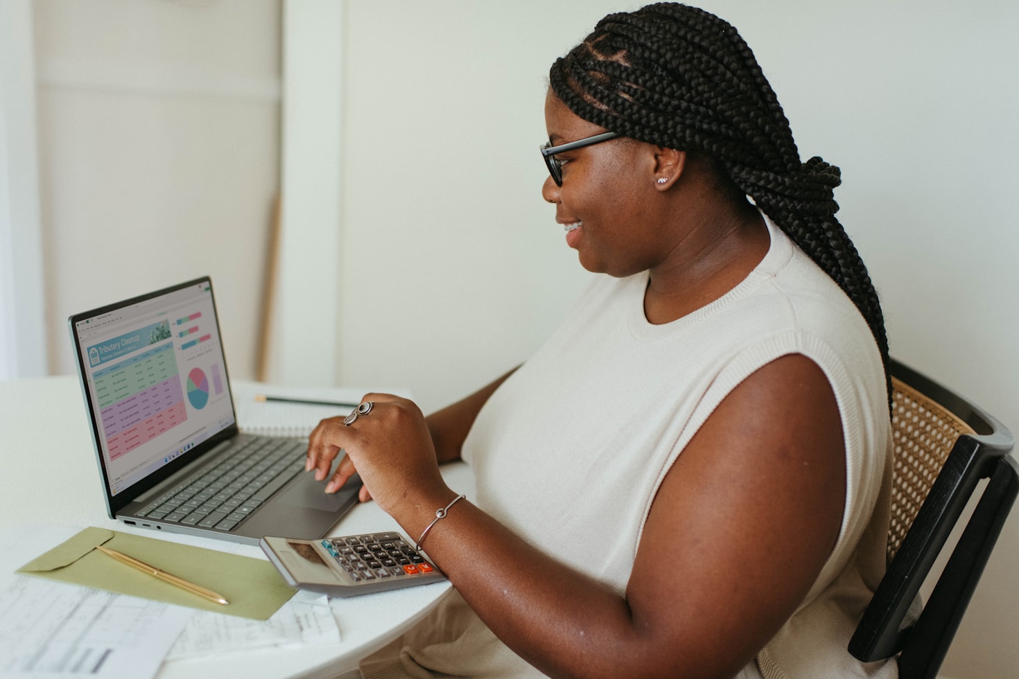 Black woman sits at her table, working on her laptop. Be your own boss jobs are out there!
