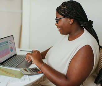 a person sitting at a table using a laptop computer