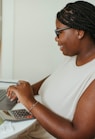 a person sitting at a table using a laptop computer