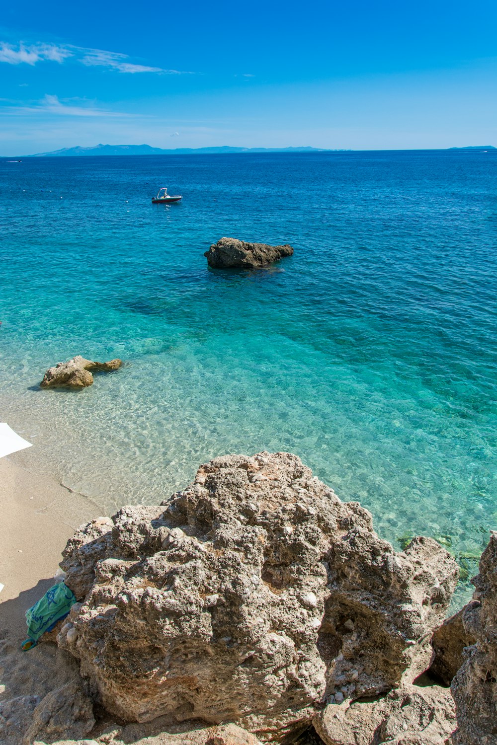 a rocky beach with a boat in the water