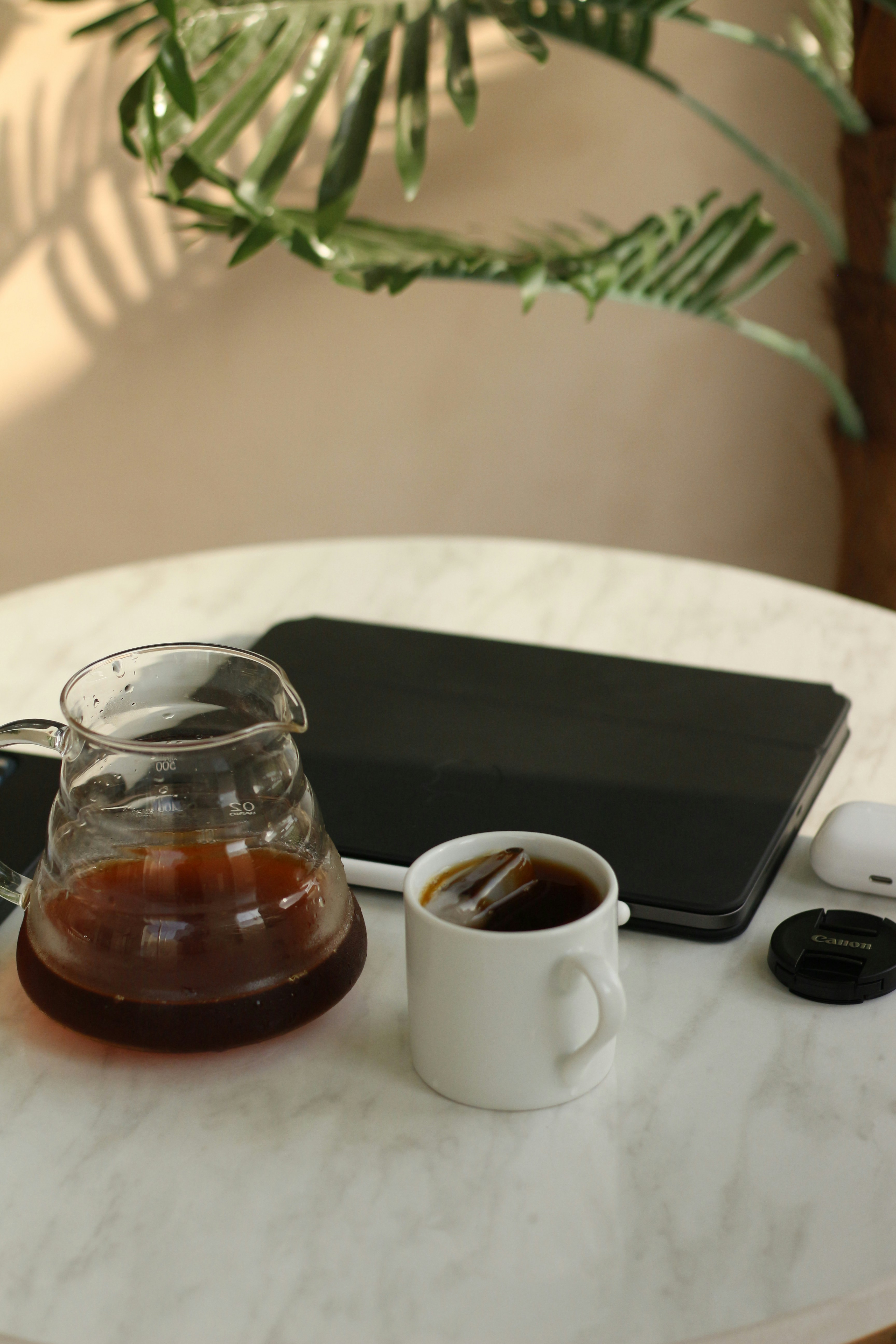 a glass of liquid next to a laptop and a glass of water