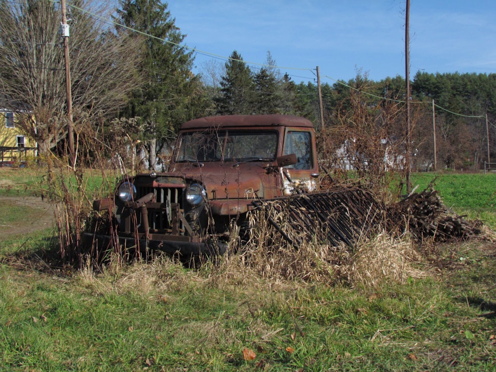 an old rusted out truck in a field
