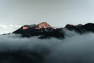 a mountain with clouds below