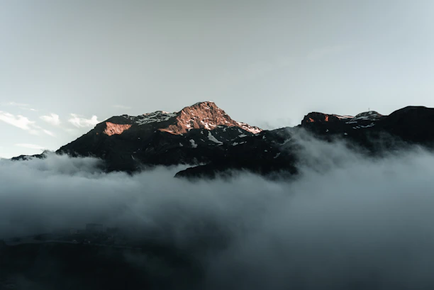a mountain with clouds below