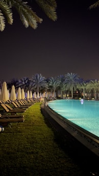 a pool with chairs and umbrellas by it
