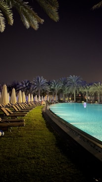 a pool with chairs and umbrellas by it