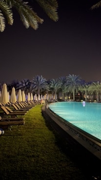 a pool with chairs and umbrellas by it