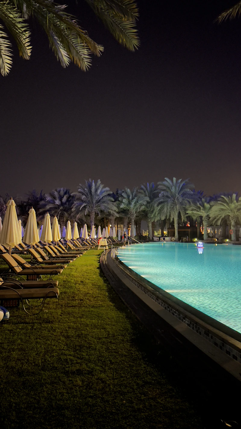 Swimming pool with loungers at night in Dubai