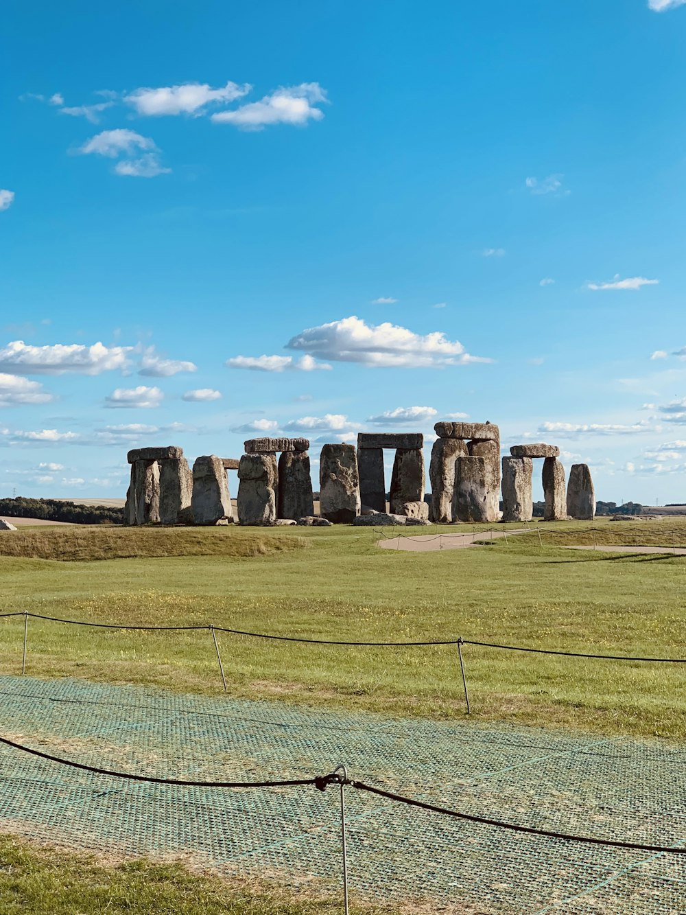 a grassy field with a stone structure in the distance