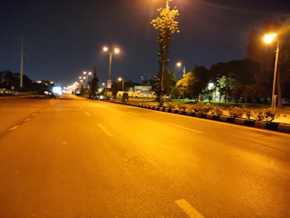 A well-lit city street at night showing smooth pavement and bright LED streetlights.