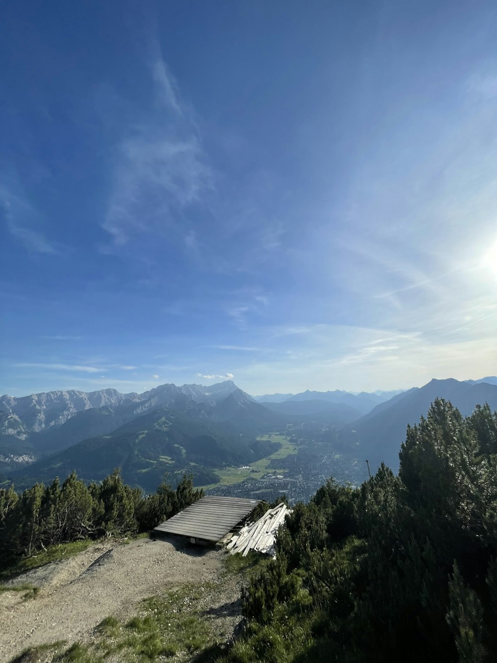 a building on a hill with trees and mountains in the background