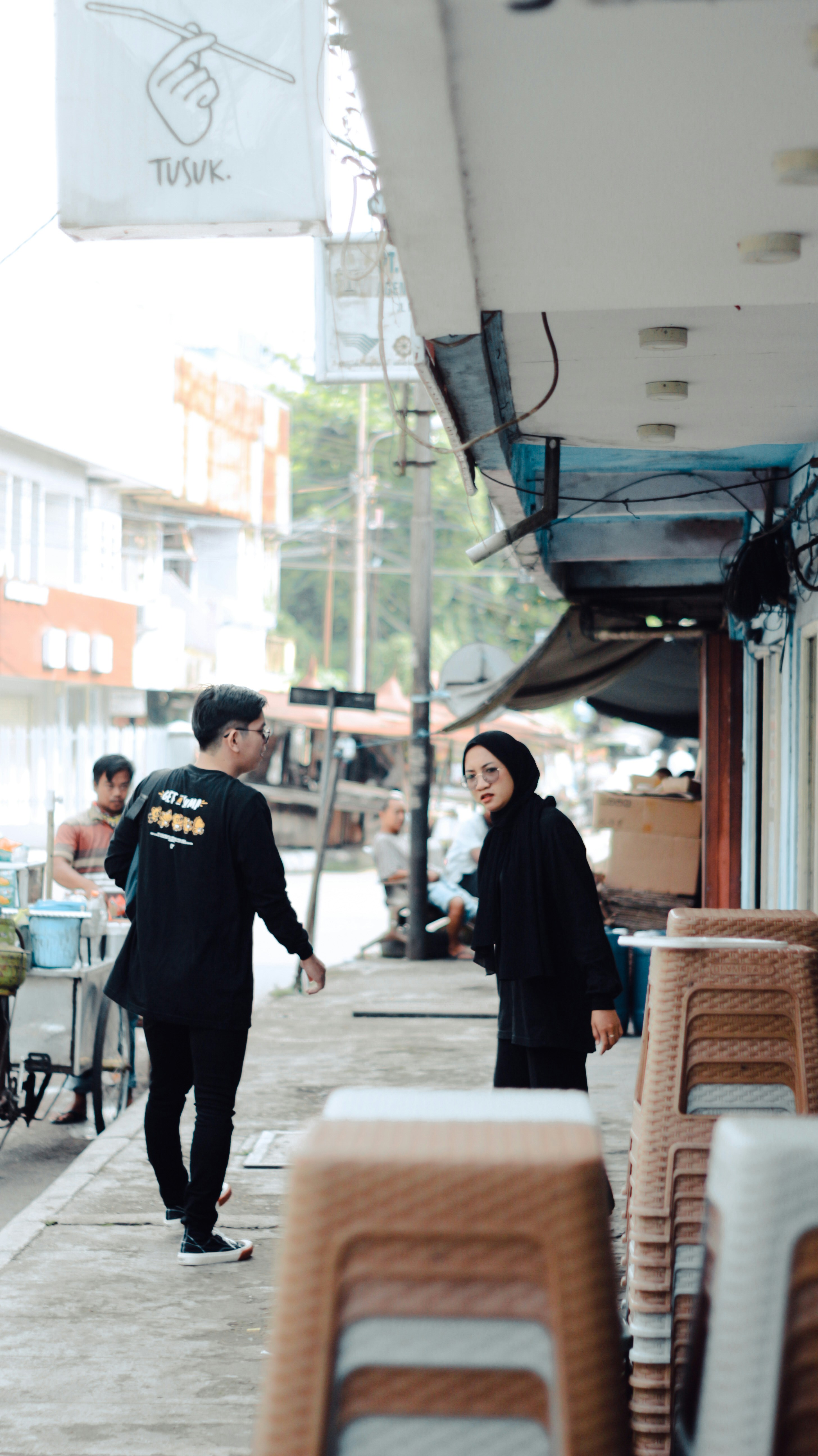 seorang pria dan wanita berjalan di trotoar